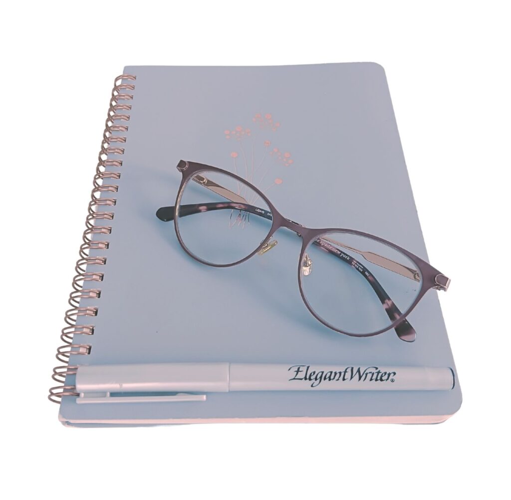 Closed notebook and reading glasses on table symbolising clarity and focus in website design